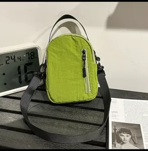 Green nylon crossbody shoulder bag casual minimalist small handbag with zipper front pocket.