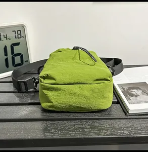 Casual minimalist green nylon drawstring crossbody bag for women with adjustable strap.