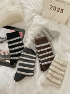 Cozy thick winter wool socks with colorful speckles and classic stripes detail close up view.