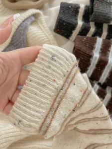 Close-up of cozy winter wool socks detail, soft knitted striped texture with colorful flecks.