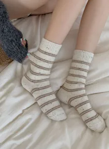 Detailed close-up view of women's thick warm wool socks with brown stripes and cute nep yarn.