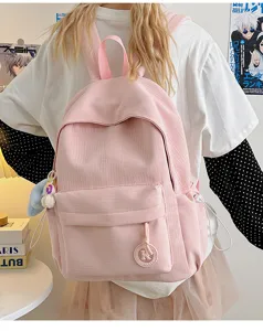 Detail shot of the pink canvas casual school backpack showing textured fabric and front pocket.