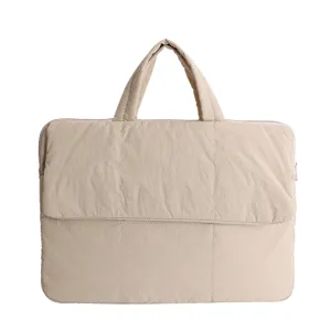 Close-up of beige quilted laptop bag handle and soft padded texture for daily commute use.