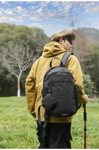Vue détaillée du sac à dos noir à carreaux d'extérieur avec une petite pochette pratique.