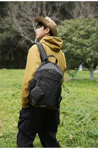Vue détaillée du sac à dos noir à carreaux en plein air avec tissu résistant et sangles.