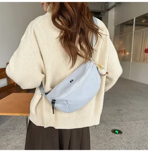 Detailed shot of a light blue crescent crossbody chest bag, casual style for women.
