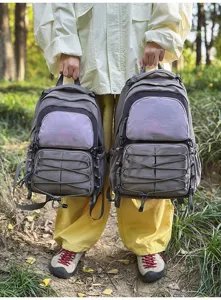 Detail view of color-block student backpacks in outdoor setting, featuring large and small sizes.