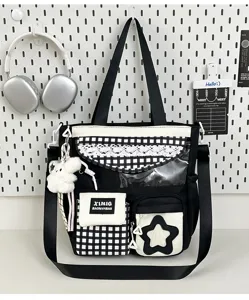 Black and white canvas tote bag detail view with grid pattern, lace, and cute bunny charm.