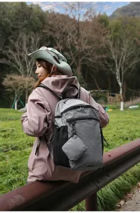 Vue détaillée d'un sac à dos gris à motifs porté par un modèle en plein air.