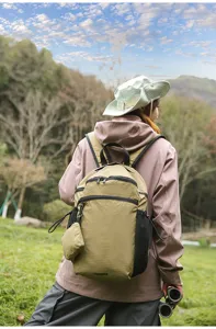 Détail de sac à dos outdoor avec tissu à carreaux, petite pochette et grande capacité.
