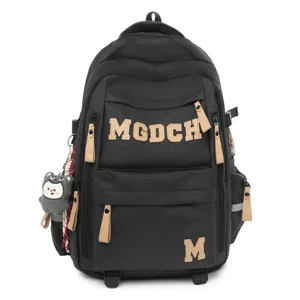 Detailed view of the black student backpack featuring MGDCH letters and cute plush charm.