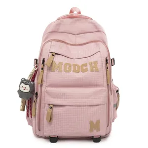 Pink grid student backpack detail with letter patch decoration and cute plush pendant design.