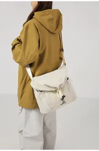 Detailed view of the casual utility messenger bag showing side mesh pockets and shoulder strap.