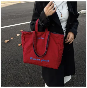 Shopper rossa casual da donna con ricamo blu, ideale per il lavoro quotidiano e il tempo libero.