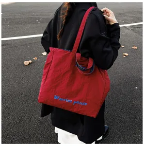 Vista dettagliata della borsa tote rossa casual con ricamo, presentazione di stile urbano.
