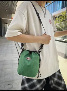 Green grid nylon drawstring bucket bag, casual lightweight shoulder crossbody bag for daily travel.