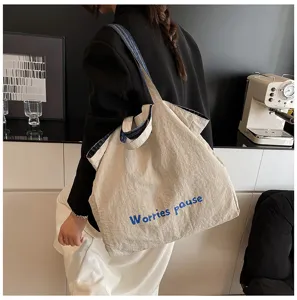 Vista dettagliata della borsa tote casual in tela in stile corneo con comodi manici.