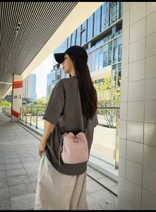 Casual lightweight nylon candy color neutral drawstring bucket bag detail view showing texture.