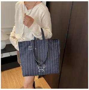 Vista dettagliata di una borsa shopper in tela a righe casual, borsa a spalla capiente per donna.