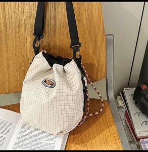 Casual lightweight nylon drawstring bucket bag detail view showing grid pattern and strap.