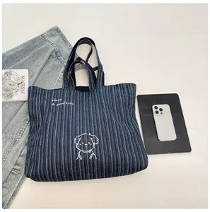 Dettaglio della borsa tote in tela con motivo a righe, ricamo di cane carino e design spazioso.