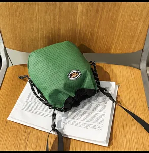 Green grid nylon drawstring bucket bag, casual lightweight travel shoulder crossbody bag.