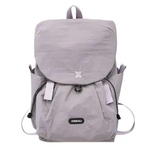 Vue détaillée du sac à dos gris léger avec fermeture à rabat sécurisée et poches latérales pratiques.