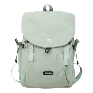 Gros plan du sac à dos vert clair doté d'un rabat à cordon, d'un badge et tissu résistant.