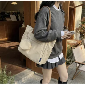 Λεπτομερής όψη της casual τσάντας tote από καμβά με λουρί ώμου και στρογγυλή θήκη.