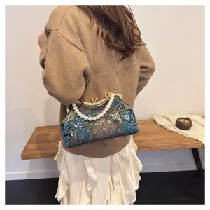 Vue détaillée du sac bandoulière vintage brodé de style chinois avec poignée en perles.