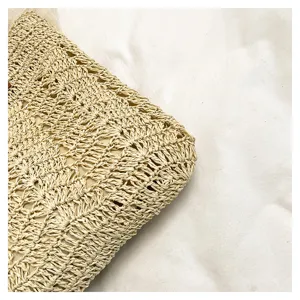 Primo piano dettagliato di una borsa da donna in paglia beige con texture squisita.
