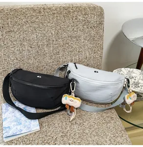Casual nylon crescent chest bag and crossbody waist bag with cute plush charm for women.