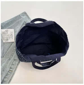 Vista dettagliata dell'interno spazioso della borsa tote in tela blu scuro e manici.