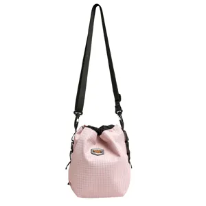 Detail view of the pink grid nylon drawstring bucket bag, showcasing the nice strap and texture.