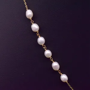Close-up detail of baroque freshwater pearl station chain necklace with delicate gold link.