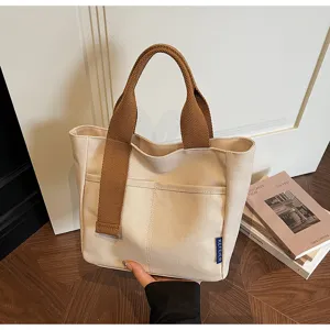Borsa tote casual in tela con manici marroni, design semplice per shopping e viaggi.