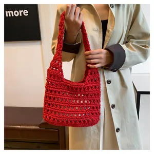 Dettaglio borsa a spalla hobo lavorata a maglia rossa, design traforato e filato morbido.