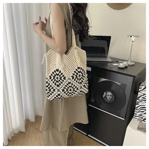 Détail du sac cabas en crochet bicolore beige et noir, sac porté épaule pour plage élégant.