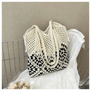 Vue détaillée du sac cabas au crochet noir et blanc avec motif ajouré et anses tressées.