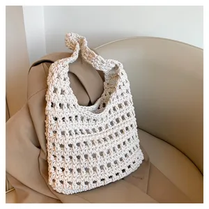 Vista dettagliata di una borsa tote lavorata a maglia beige, stile casual, borsa a spalla.