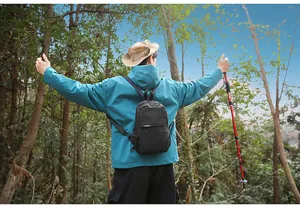 Vista detallada de una bolsa de pecho de nylon a cuadros negros en un entorno forestal.