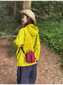 Outdoor red plaid mini crossbody phone bag detail view worn by model in forest environment.