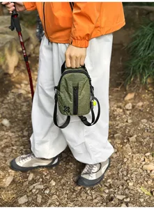 Mini green grid crossbody bag for outdoor hiking, commuting, and travel use with zipper.