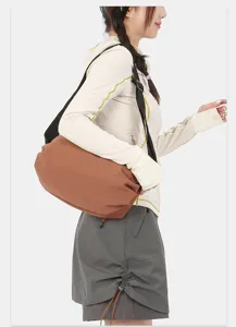 Detail view of the casual nylon crossbody bag showing the adjustable strap and soft brown body texture.