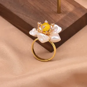 Primo piano dettagliato del raffinato anello con fiore di perla barocca e fascia regolabile.