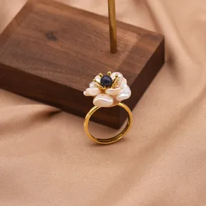 Primo piano dettagliato dell'anello con fiore di perla barocca, fascia regolabile.
