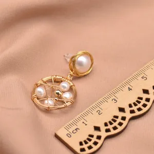 Elegant geometric pearl drop earrings detailed view showcasing wire-wrapped design and natural pearls.