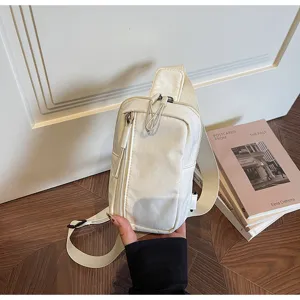 Detail view of stylish white canvas chest bag with zipper pocket, casual sling crossbody bag.