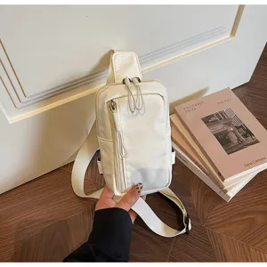Detailed view of casual white canvas chest bag, stylish crossbody sling bag with zip pockets.
