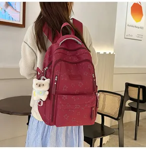 Stylish burgundy star backpack detailed view, featuring a cute bear pendant and large capacity.
